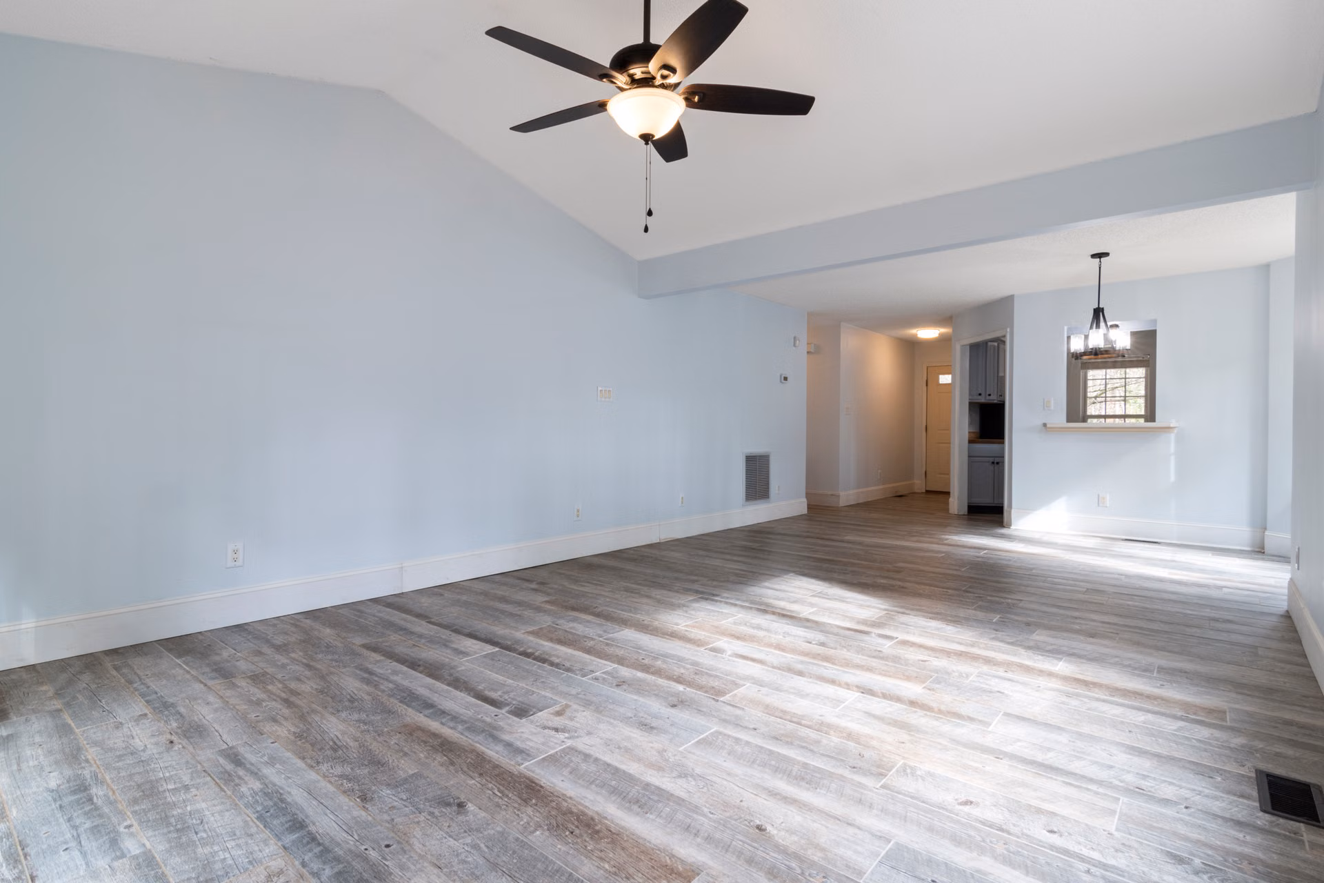 Open living area with freshly painted walls and a ceiling fan