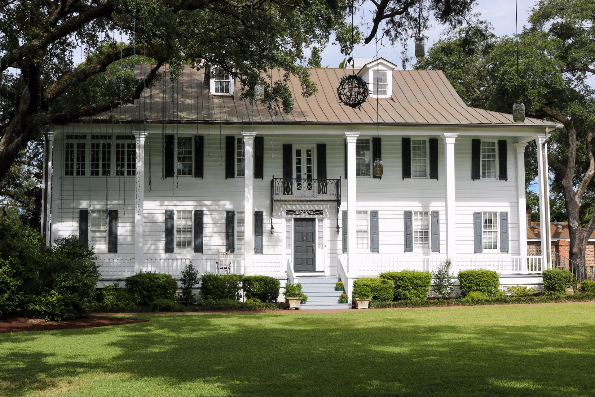 Stately white two-story home with columns and a wide green lawn